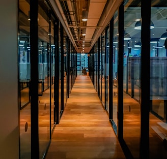 glass paneled long wooden floored hallway