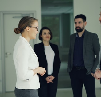 Business professionals conversing in a modern office hallway.